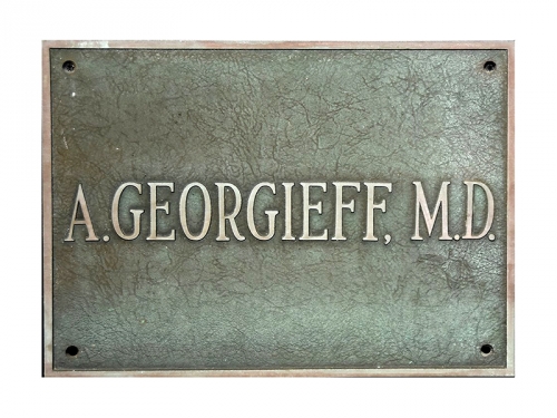 Табелата от лекарския кабинет на д-р Андрей Георгиев в Уилмингтън. Тя е подарена от негови близки на гимназия „Найден Геров” – Лом.